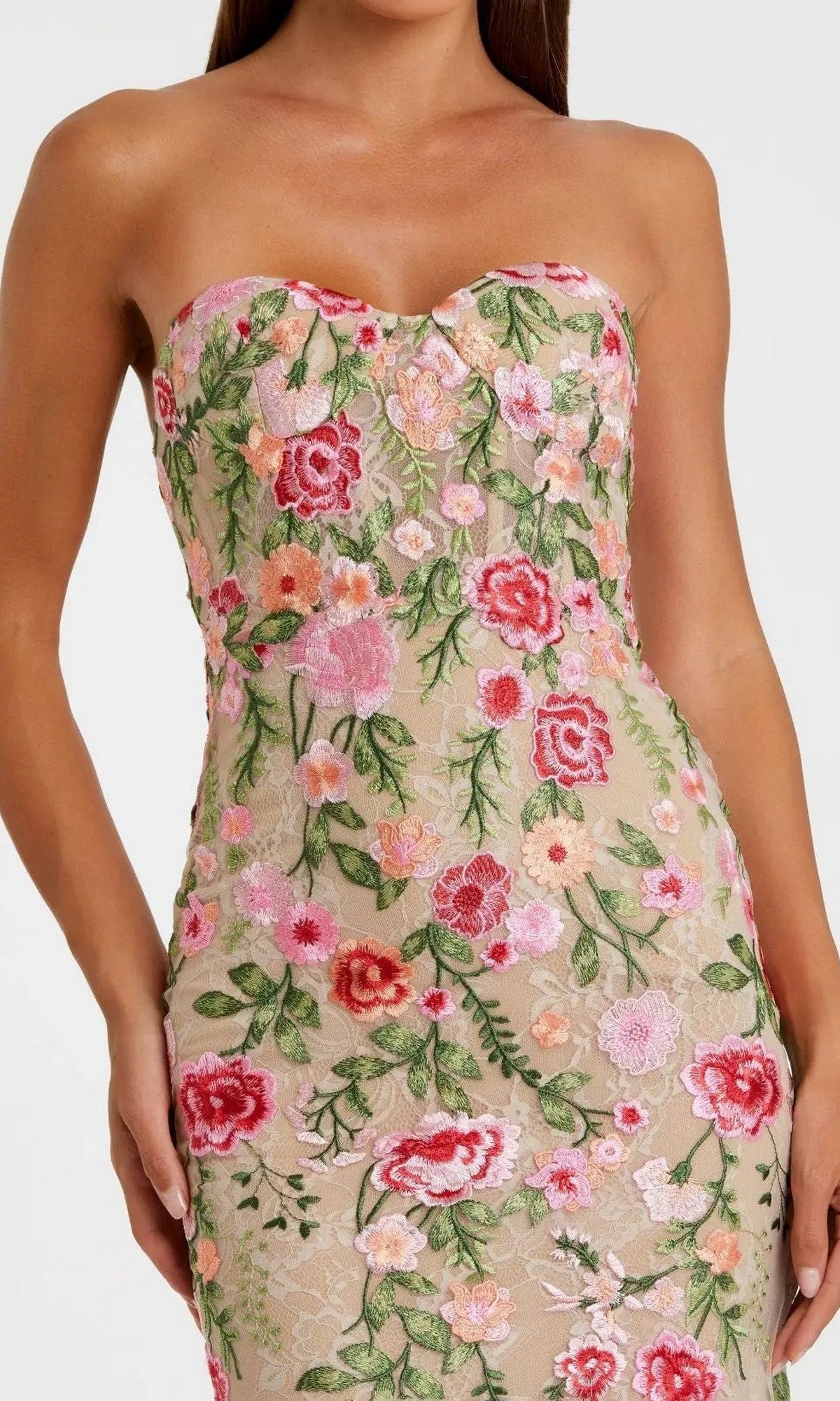 A woman wearing the Long Formal Dress: Mac Duggal 68894, a strapless beige gown featuring colorful floral embroidery in pink, red, and green.